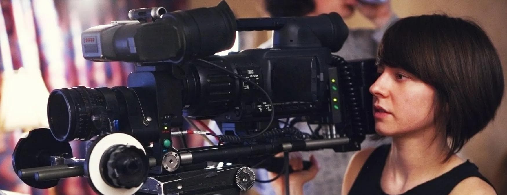Une jeune femme qui utilise une caméra pour un enregistrement vidéo 