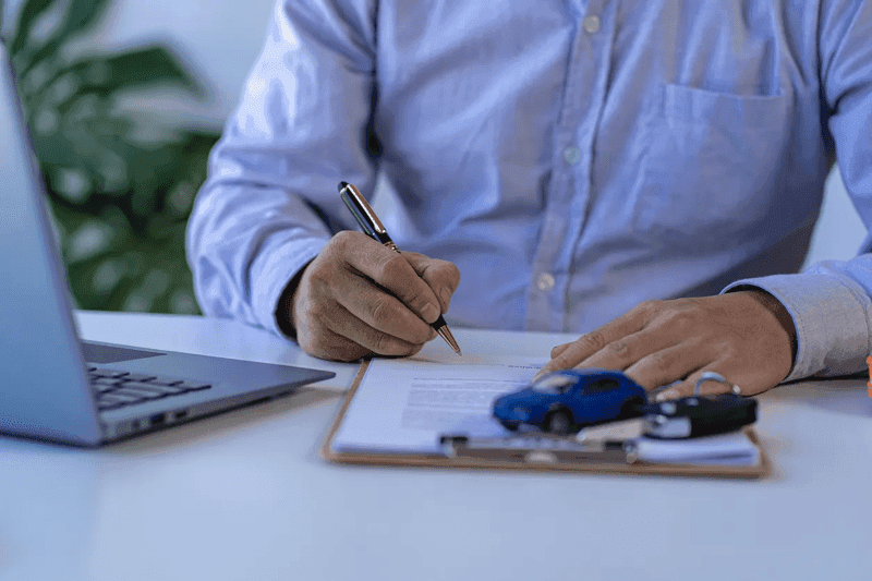 Concessionnaire qui donne des clés au propriétaire d’une voiture neuve dans un concessionnaire automobile