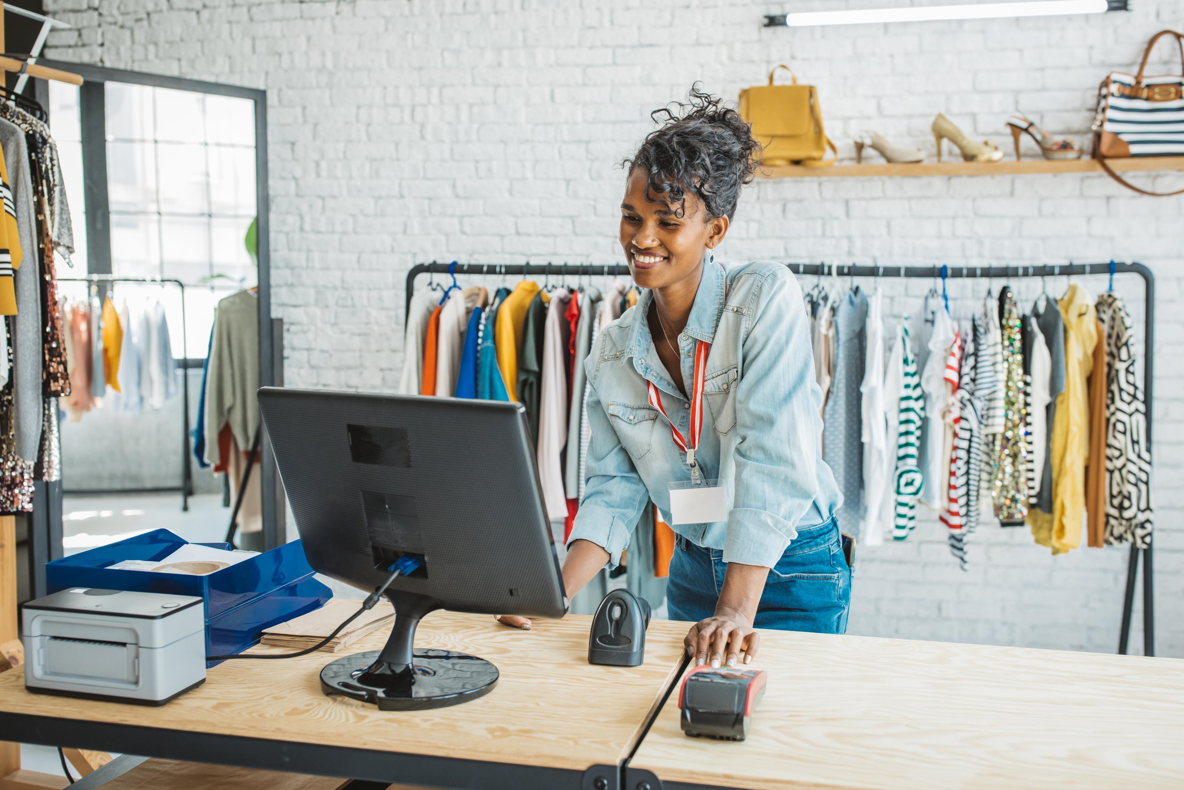 Propriétaire d'une petite entreprise ethnique souriant joyeusement dans sa boutique.
