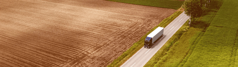 Un camion de 18 roues conduisant à la campagne en été.