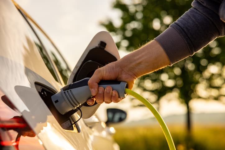 Homme chargeant un véhicule électrique
